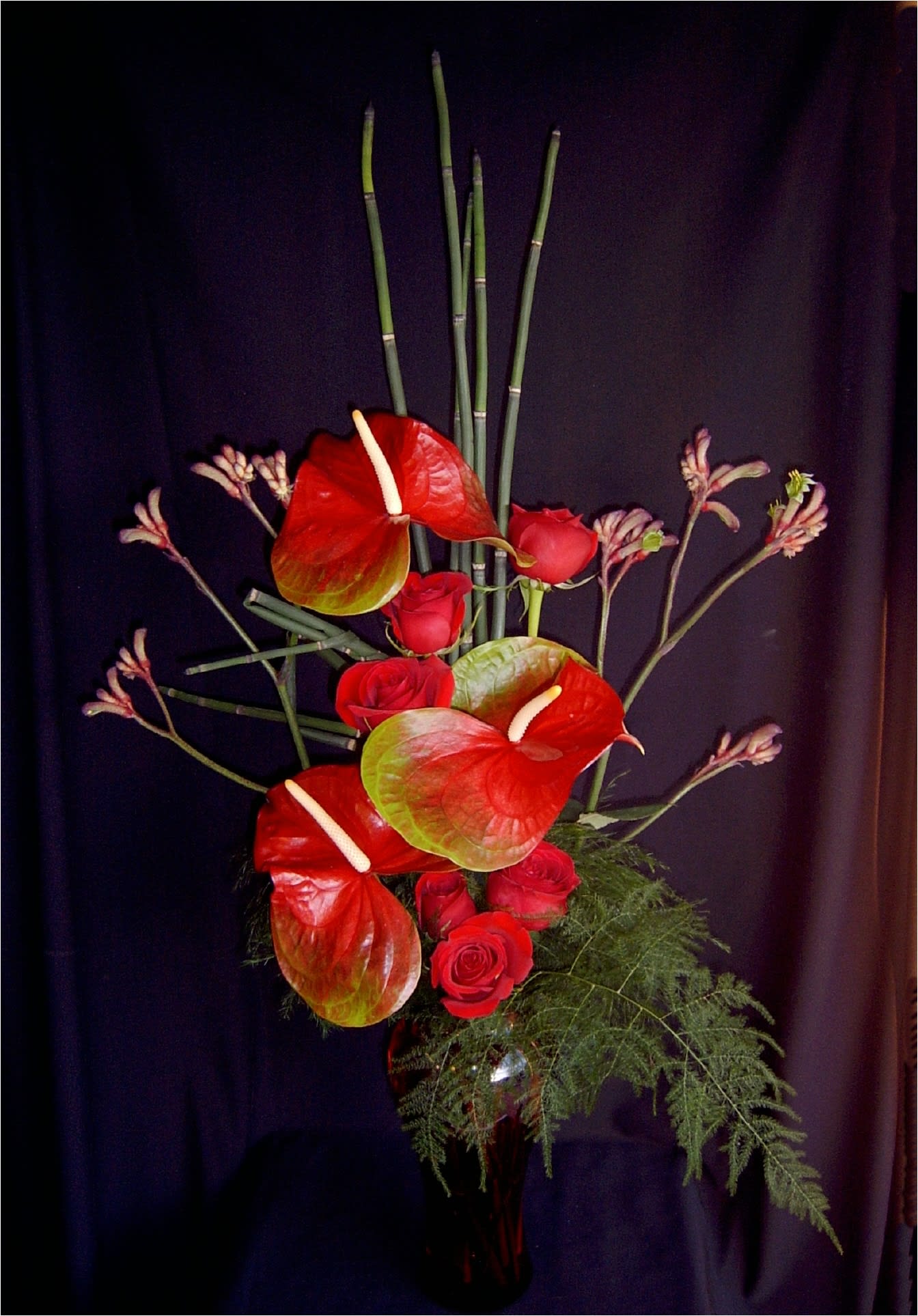 Anthurium Rose Seduction - The most seductive valentines roses should pair with these large tropical anthurium flowers, don't you agree? We select only the finest exotic accent flowers and half a dozen red roses and we arrange them with three large heart shape anthurium.  If you prefer another color, please let us know when you place your order.
