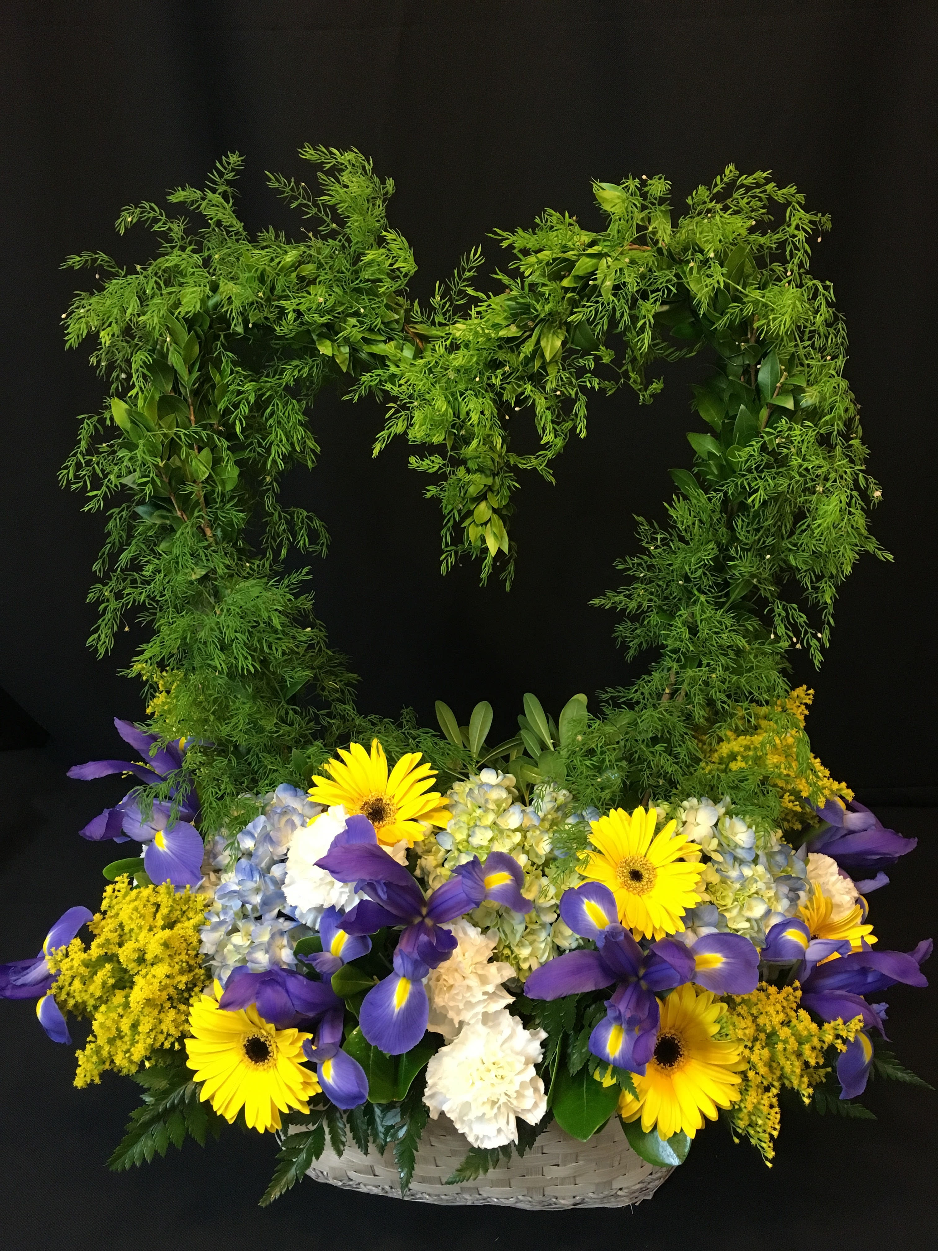 Basket arrangement with yellow daisies, purple irises, and blue hydrangeas