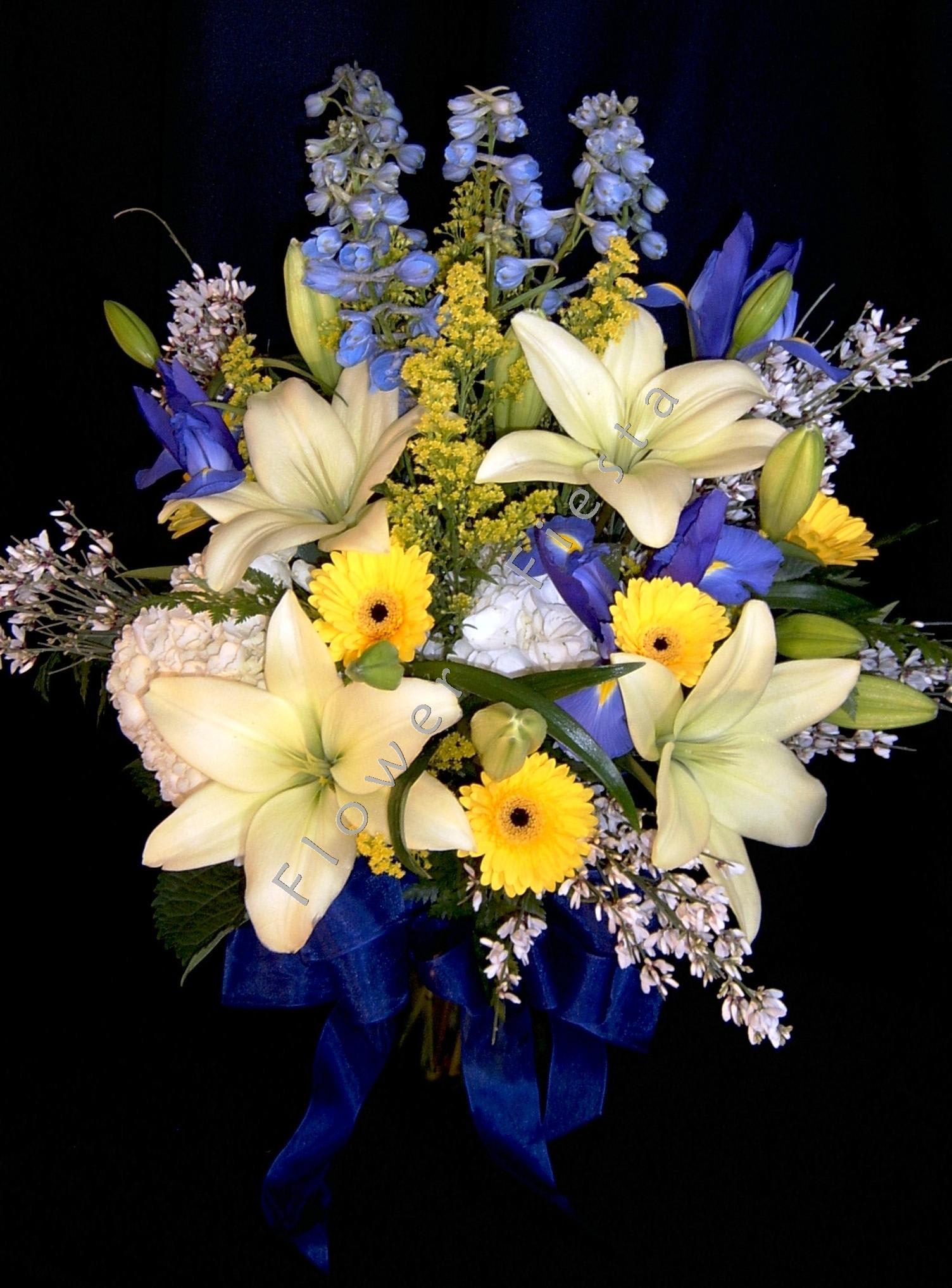 Bouquet of cream lilies, blue flowers, and yellow daisies with a blue ribbon