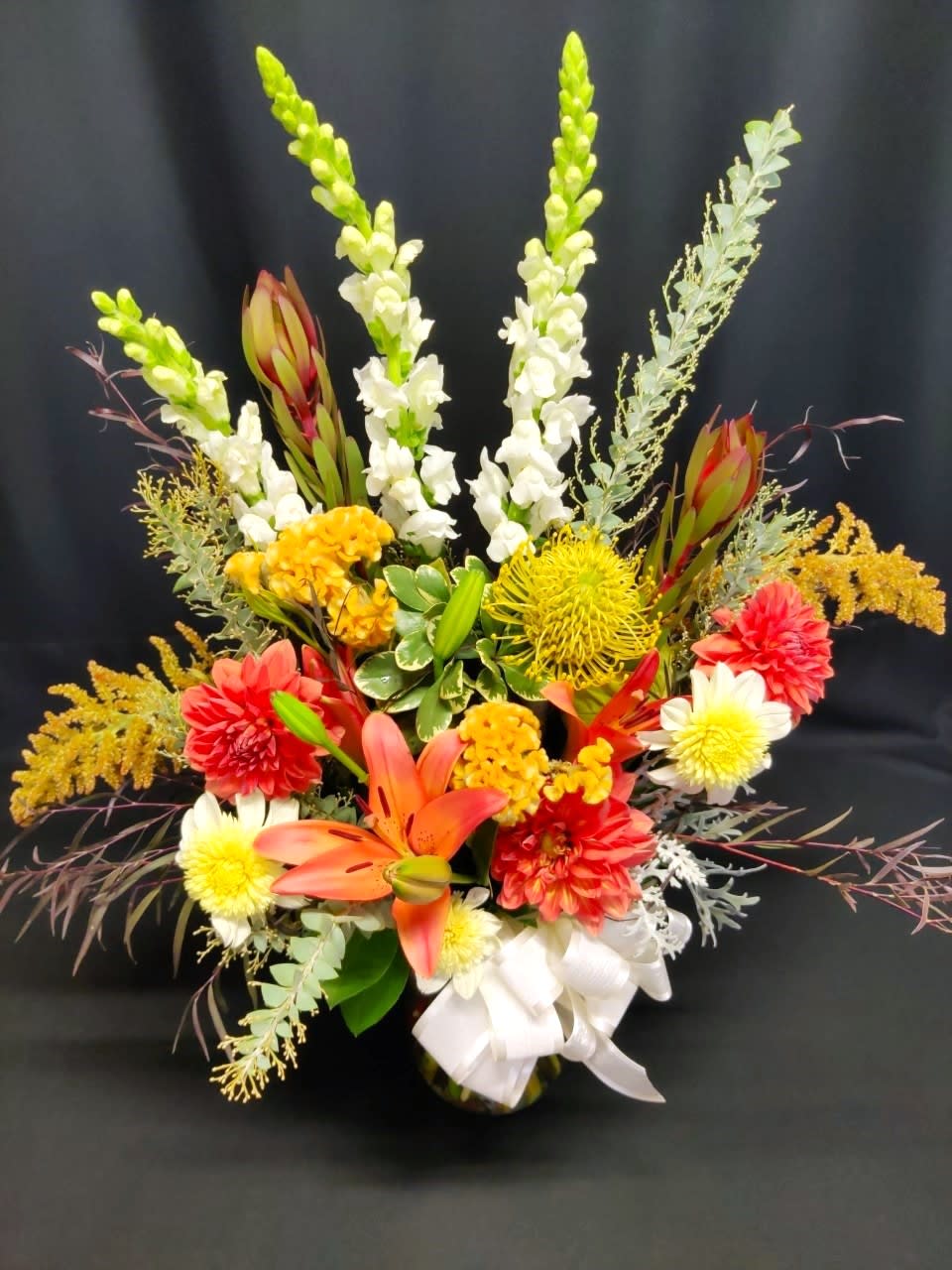 Colorful floral arrangement with lilies, snapdragons, and chrysanthemums in a vase