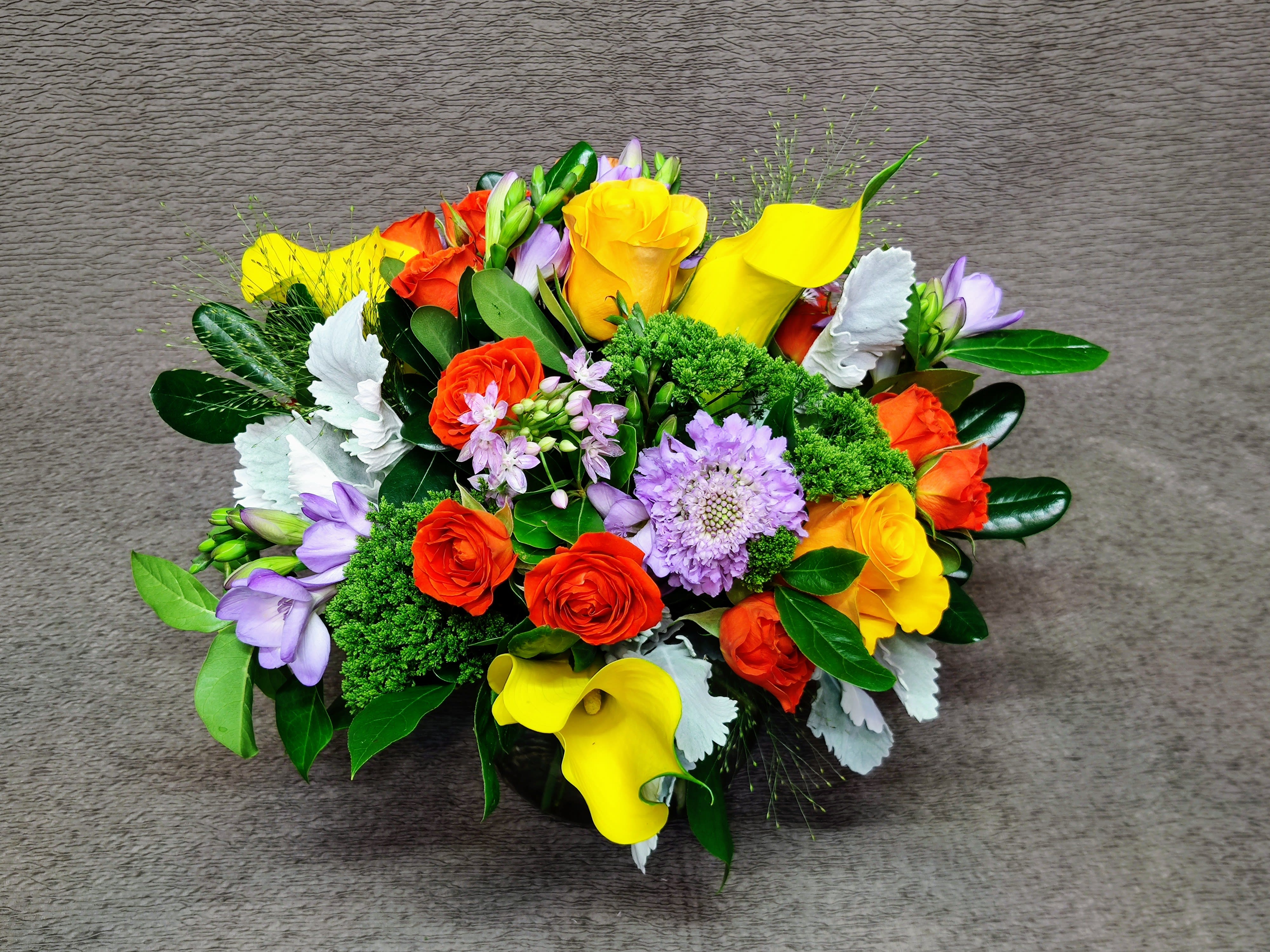 Summer Sweet Centerpiece - Assorted summer flowers and roses in playful color combinations.  Assortment and colors will vary.