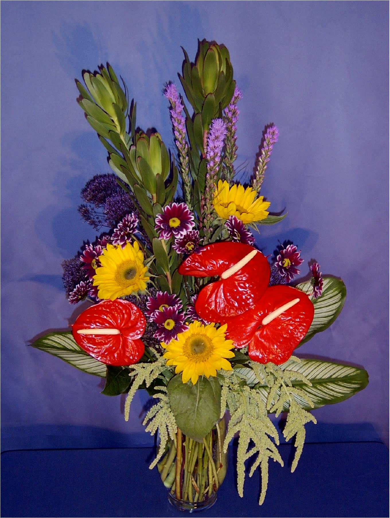 Tall Exotic Mix - Nice tall California exotic collection; we have selected premium tropical anthurium in many unique color combinations and set them against a background of bright bold California flowers and exotic foliage.  Order early for best selection!  Bright colors make this a wonderful Birthday bouquet or Father's day arrangement!