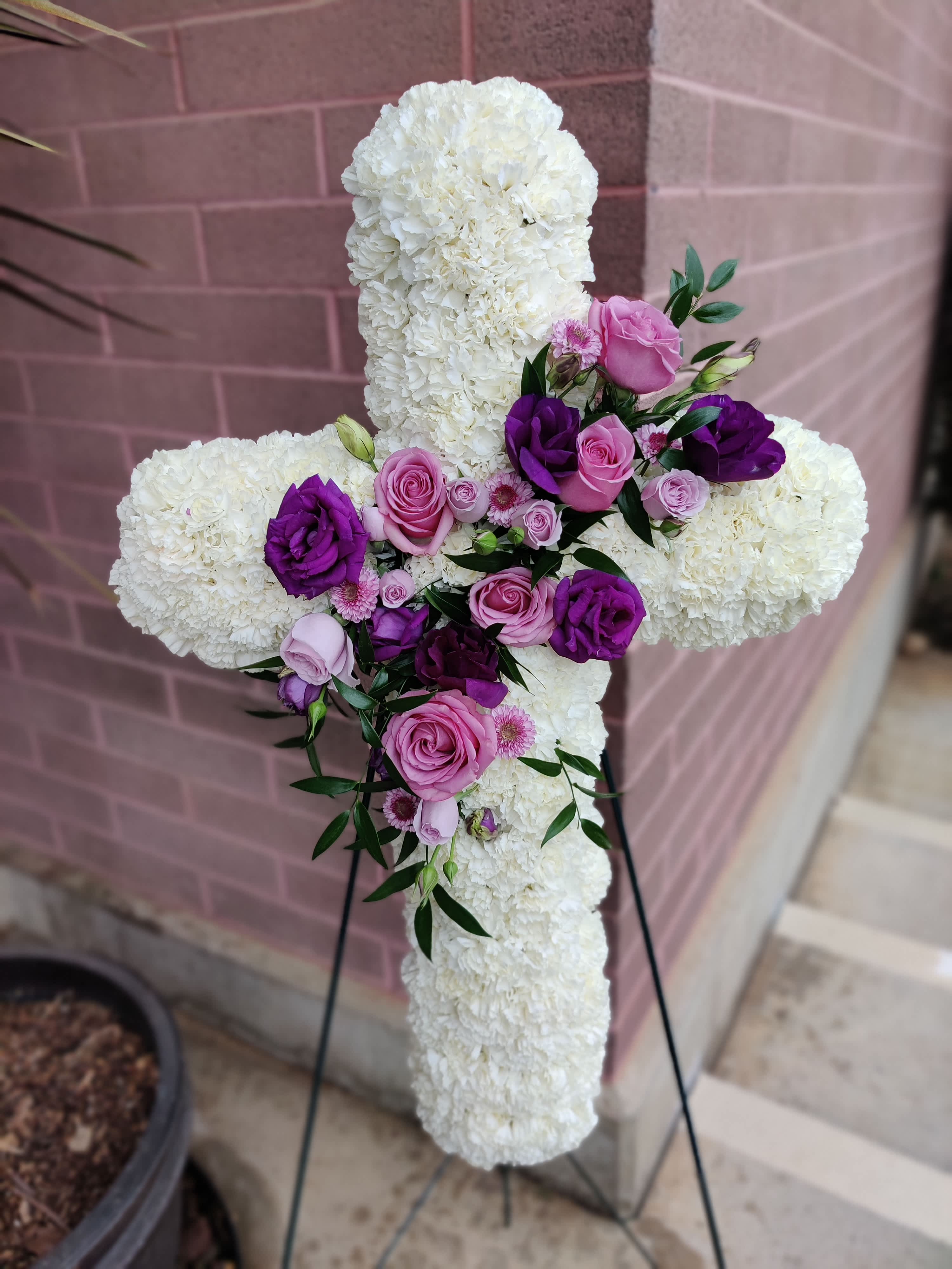 Floral Cross with Rose Center - What a touching creation to uplift at the service of your loved one.  Flowers may vary.   Sympathy Cross on Easel,   33" of flower height  We can customize the COLORS with at least 1 week's notice but we will do our best with a shorter timeframe and communicate with you. Watch for an email once you place your order as our first method of contact regarding any possible substitutions. 