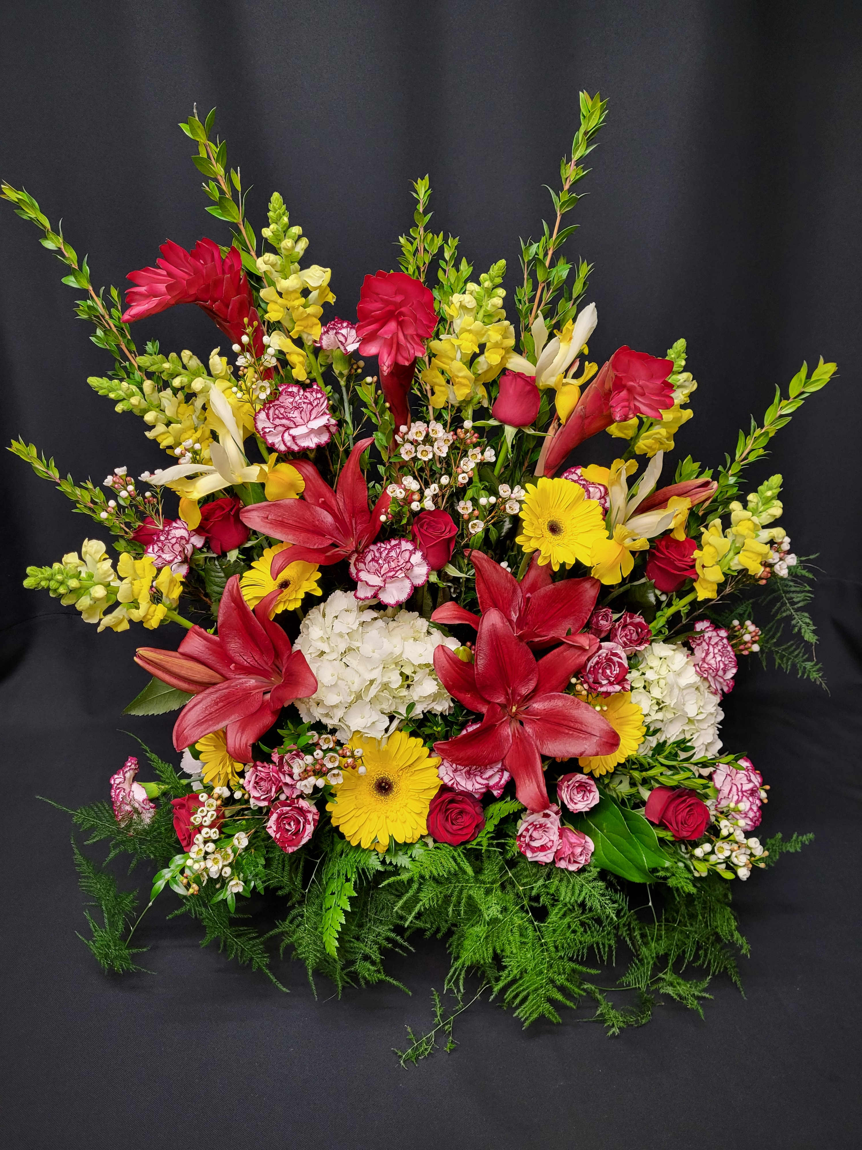 Large mixed bouquet with red lilies, yellow daisies, and pink roses