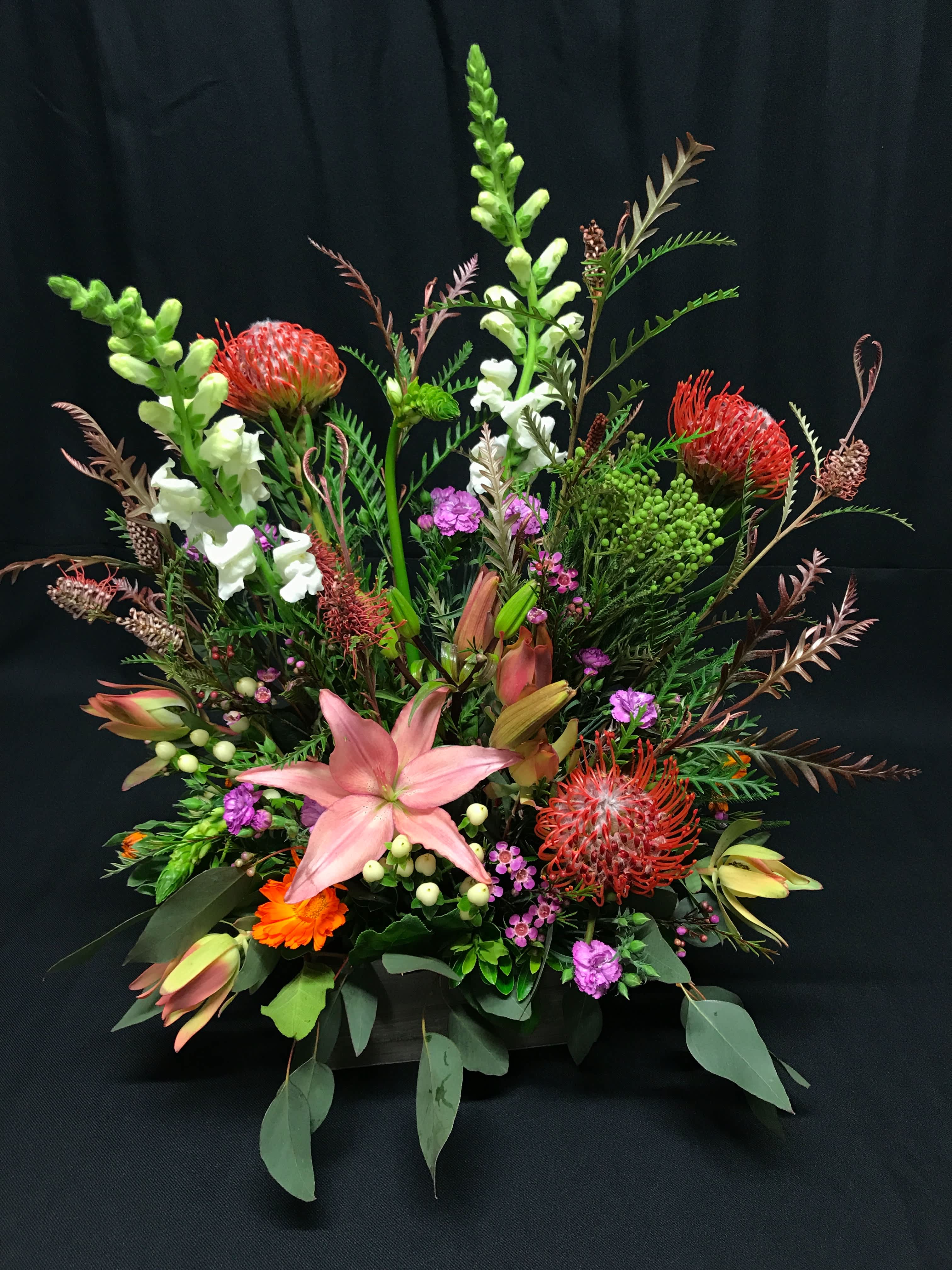Australian Botanical Box - Exquisite design of assorted African and Australian flowers. Lots of detail, texture and variety. Flowers and colors will vary. This tends to be a long lasting bouquet when watered daily. 