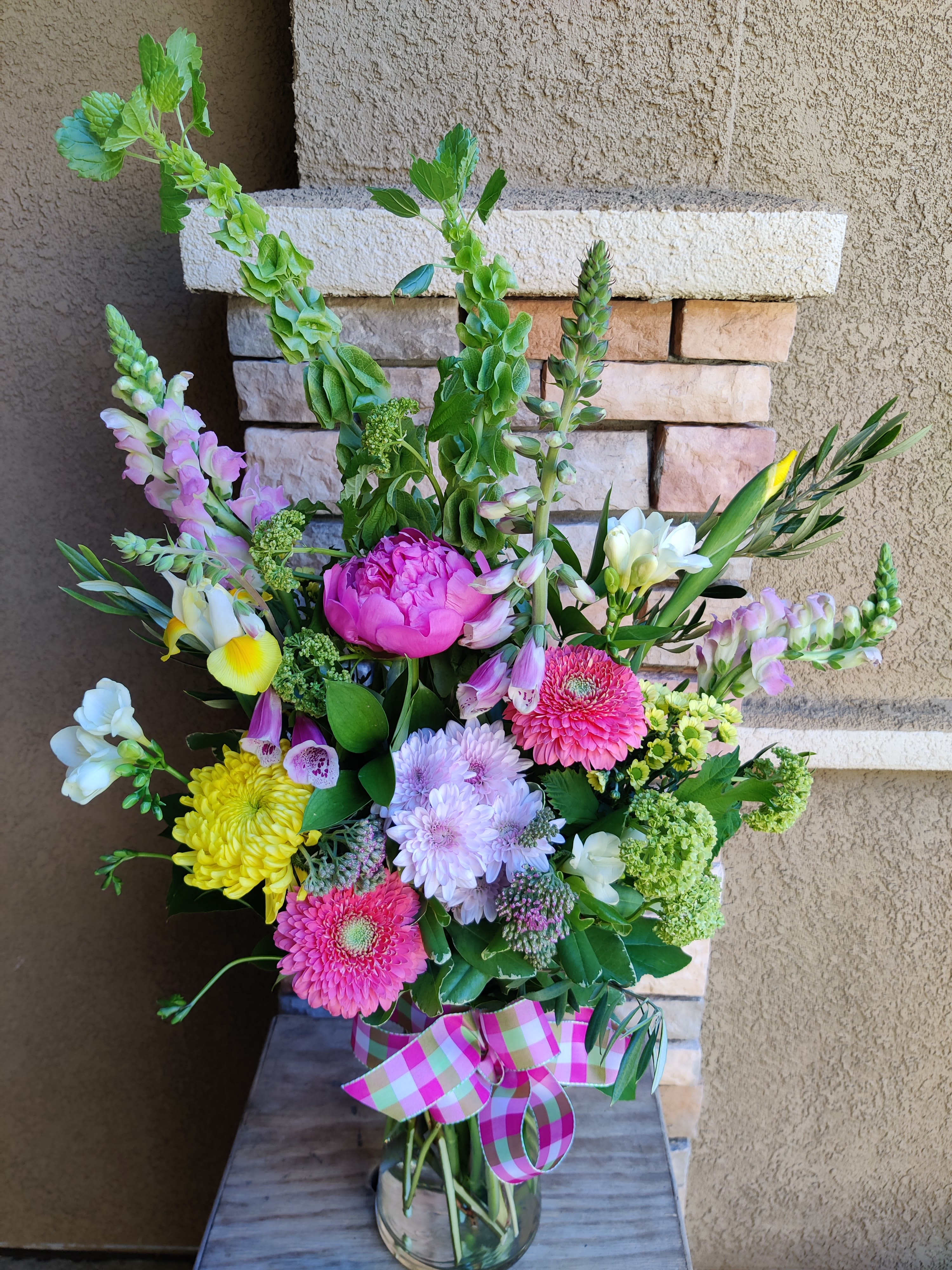 Welcome spring daisy peony bouquet - Single peony (when in stock and ordered ahead) and festive gerbera daisies at the center of this unexpected spring bouquet. Premium tall flowers and accent flowers abound. Brilliant colorful mix. 