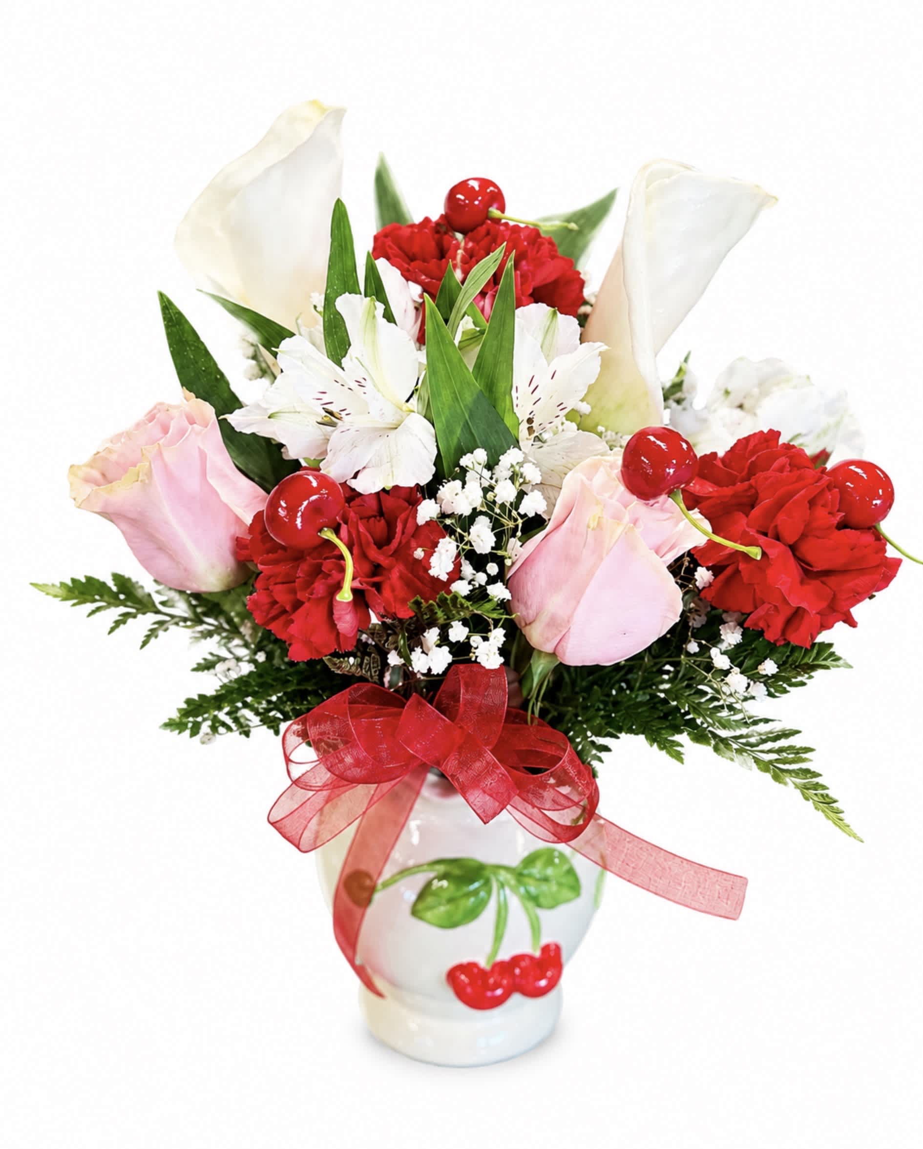 Bouquet of red carnations, pink roses, and white calla lilies in a white vase