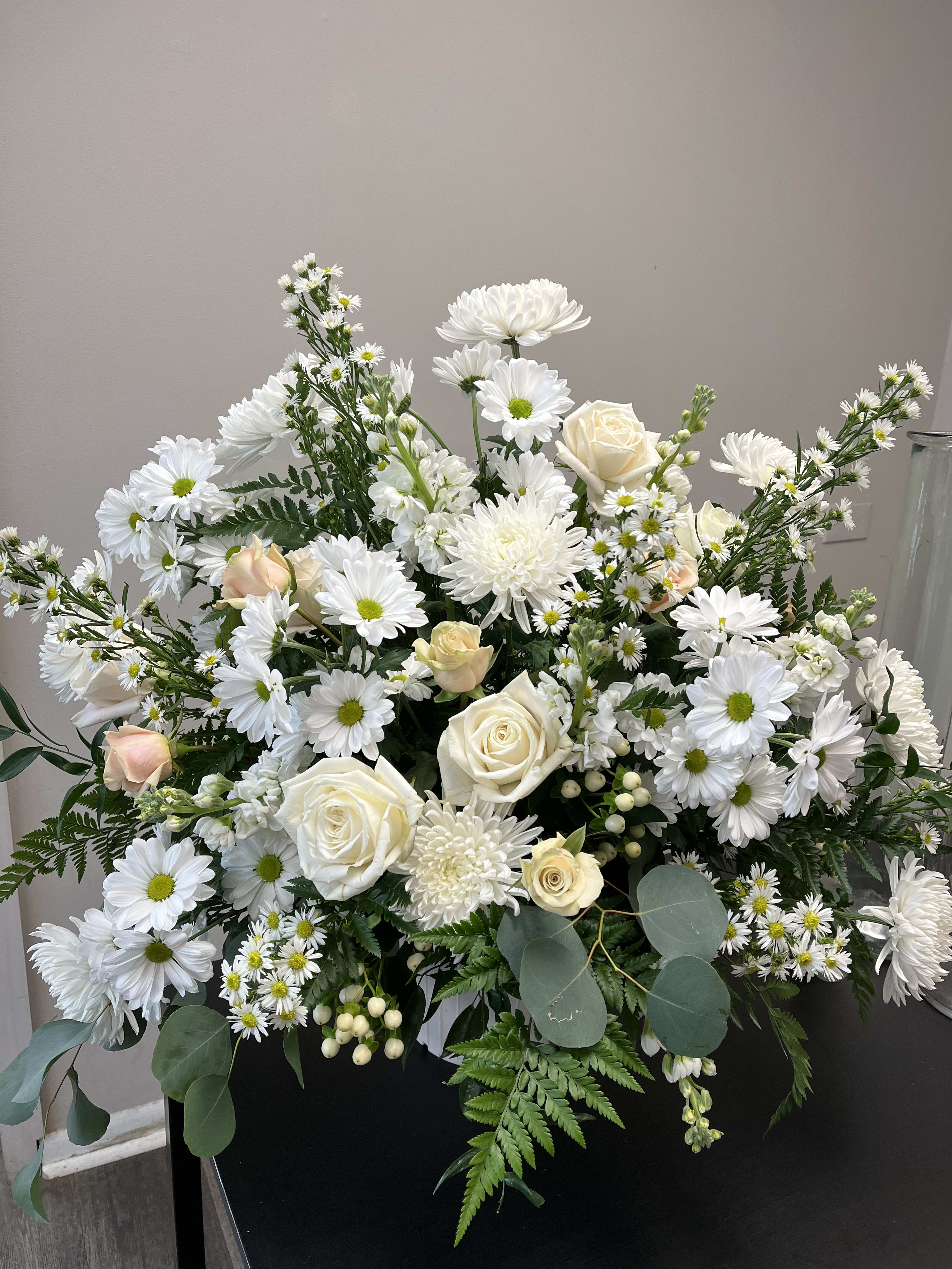 White daisies and cream roses arranged in a large bouquet