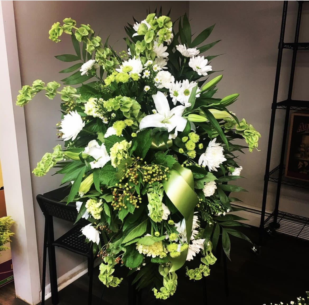 White and green standing spray - White and green standing spray. Assorted selection of neutral colored flowers arranged in a standing spray on an easel. Flower selection will vary each week 