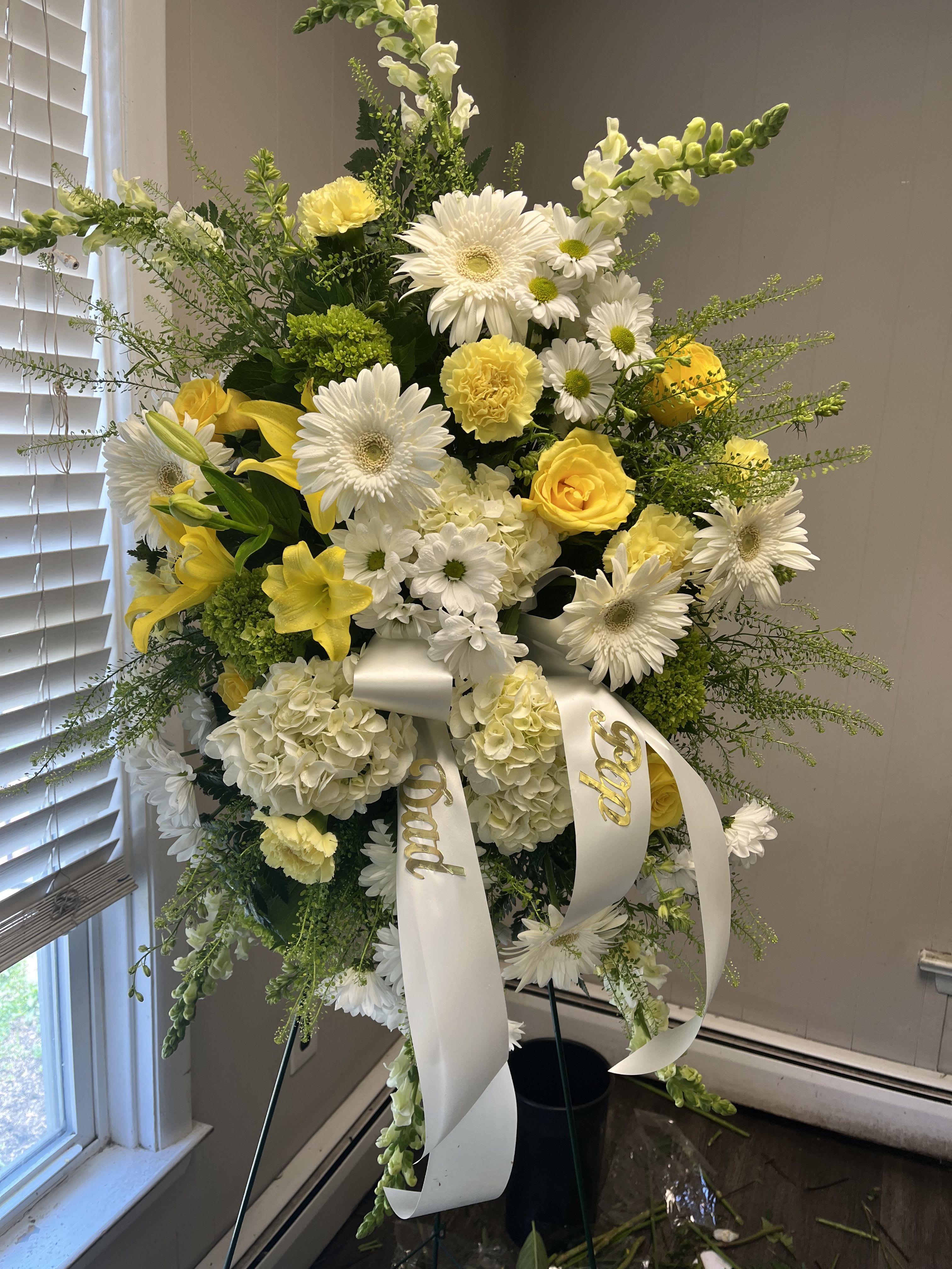 Tall white and yellow floral standing spray with ribbon