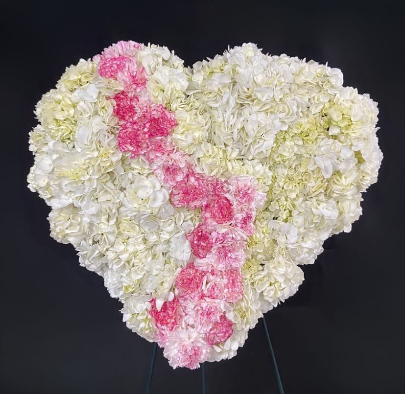 Heart-shaped floral arrangement of white and pink carnations
