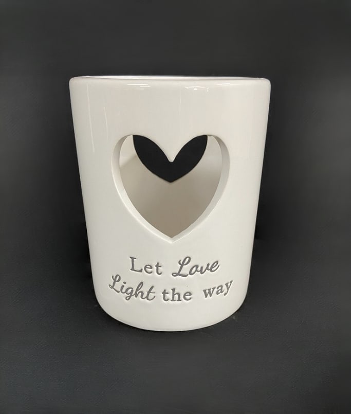 White ceramic candle holder with a heart cutout and "Let Love Light the way" text