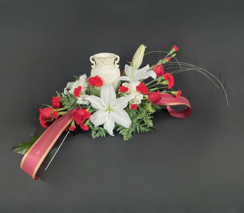 Modern Style Urn Design - With a focal point of elegant white oriental lilies, this design in free flowing and modern with roses, carnations, stock, and veronicas. Arrangement is designed to hold a standard size urn. Urn not included.