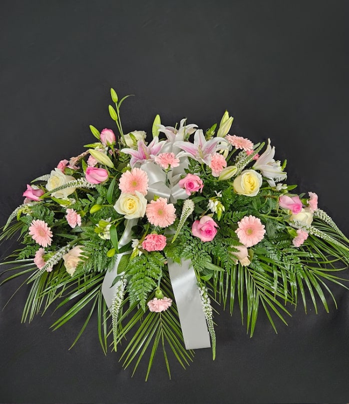 Pink and white floral spray with lilies, roses, and daisies