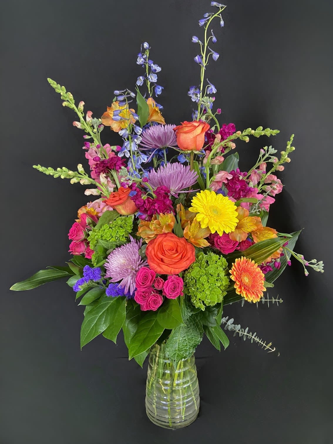 Colorful Blooms - Send an arrangement as colorful and vibrant as them! With purple stock, green Fuji mums, orange carnations, pink larkspur, and more, Colorful Blooms is a riot of fun and bursting with color. They'll love getting this enticing arrangement—it's like confetti in a vase!