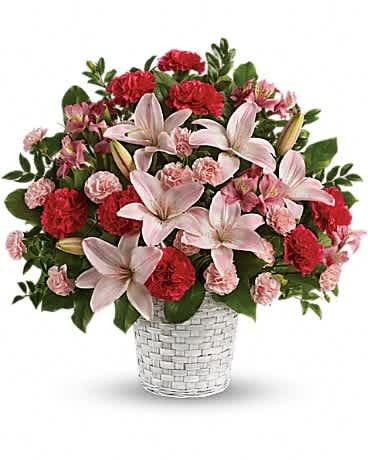 Pink lilies and red carnations in a white woven basket