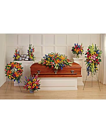 Colorful funeral casket spray with standing floral tributes