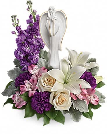 Purple and white floral arrangement with an angel figurine centerpiece