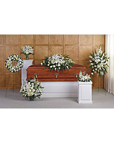 Funeral casket surrounded by white floral sprays and wreaths