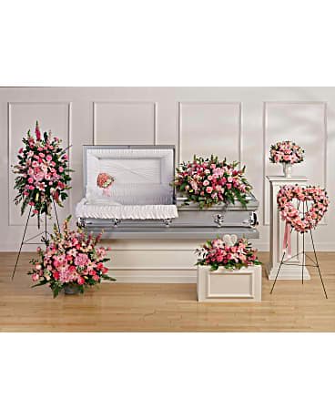 Pink floral funeral casket spray with matching standing arrangements