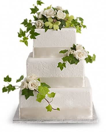 Four-tier white wedding cake with white roses and ivy