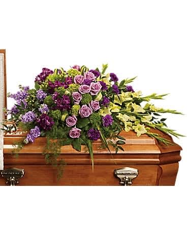 Purple and yellow floral spray on a wooden casket