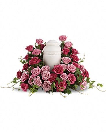 Pink and magenta roses arranged around a white urn