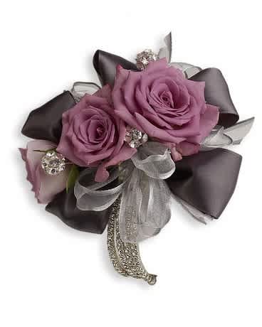 Roses And Ribbons Corsage - Lavender roses and romantic ribbons surrounded by classic rhinestones are simply spectacular. Flower and Ribbon colors can be matched to any attire. Lavender spray roses embellished with rhinestones and ribbons.