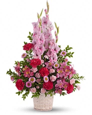 Pink and red floral arrangement in a woven basket