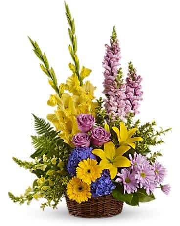 Basket arrangement with yellow lilies, purple roses, and lavender flowers
