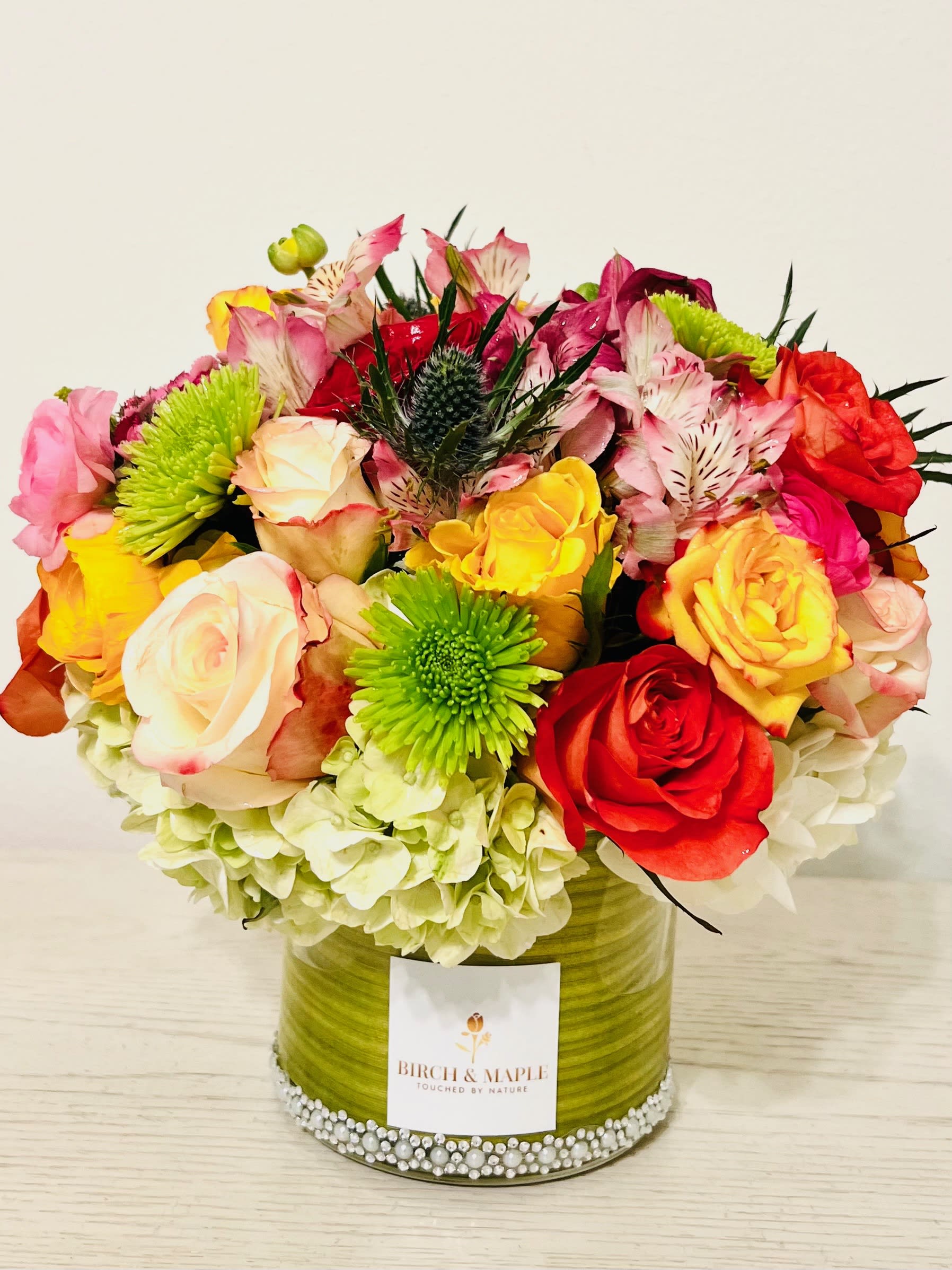 Hue - Breathtaking blooms of jubilant hues! Dive into a world of joy with our radiant arrangement of yellow red pink and orange roses carefully paired with elegant hydrangeas and seasonal foliage..Embrace nature's vibrant palette- Bring home Hue.For same day delivery and Free Delivery Options Text or Call  832-973-1376.