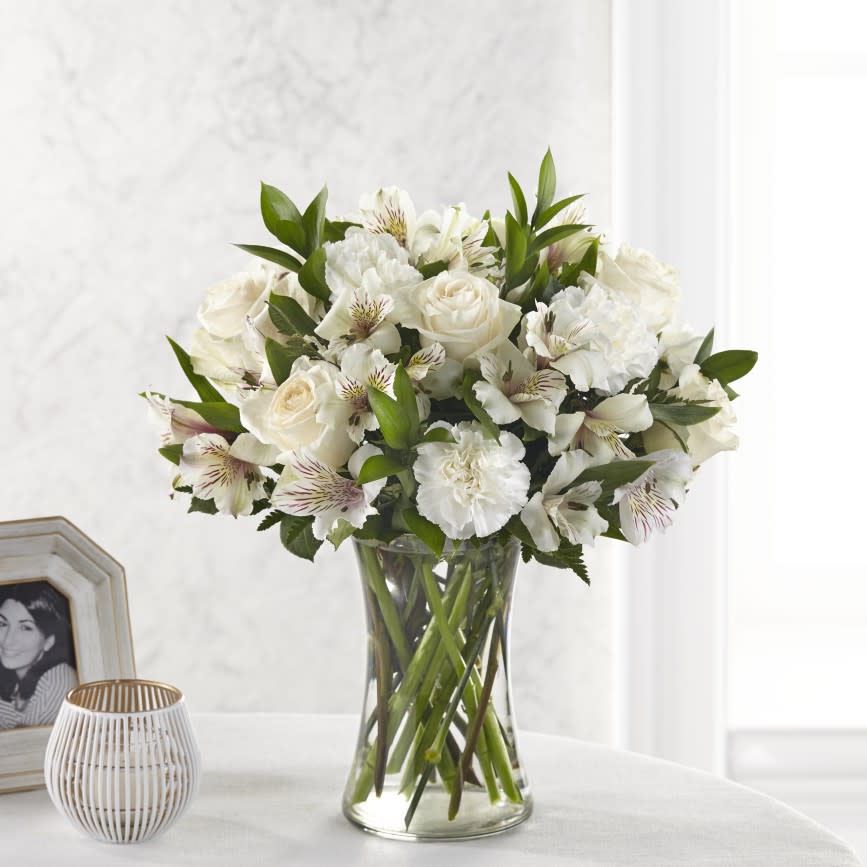 Cherished Friend Bouquet  - The Cherished Friend Bouquet offers comfort and sympathy in the time of grief and loss. White roses and Peruvian lilies are accented by lush greens and gorgeously arranged in a clear glass gathering vase to create a bouquet that will bring peace and show how much you care.  S5256