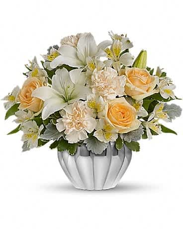 White and peach floral arrangement in a silver vase