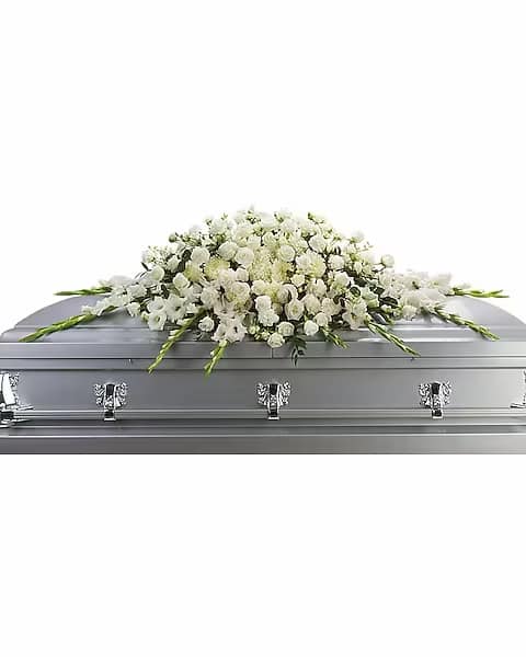 White floral casket spray on a silver casket
