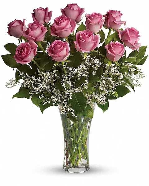 Pink roses arranged in a clear glass vase with white filler flowers