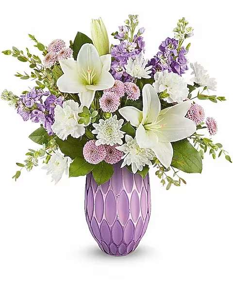 White lilies and purple flowers in a lavender vase