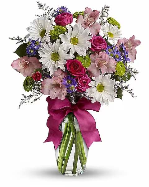 Bouquet of white daisies, pink roses, and pink alstroemeria in a glass vase