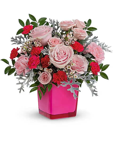 Pink and red rose arrangement in a bright pink vase