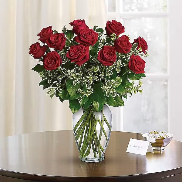 Red roses arranged in a clear glass vase