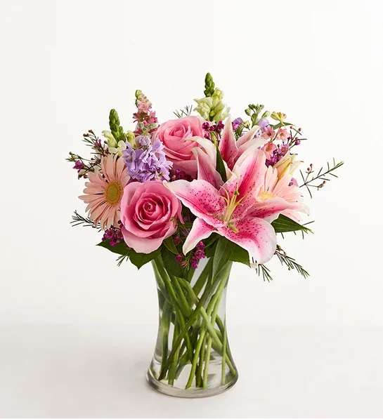 Pink roses and lilies in a clear glass vase