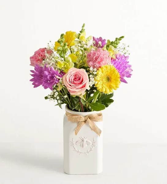 Mixed bouquet in a white vase with a burlap bow