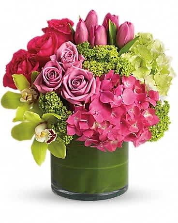 Pink roses and tulips with hydrangeas in a green glass vase