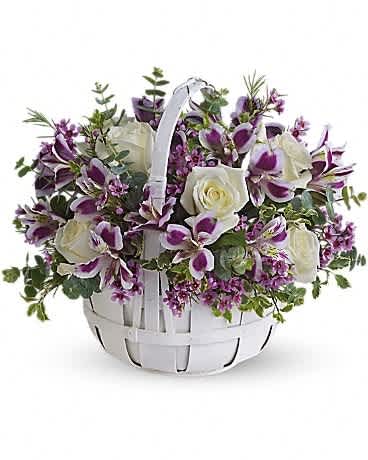 White basket arrangement with purple orchids and white roses