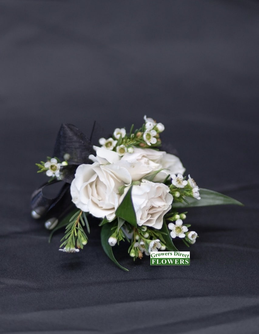 White rose boutonniere with small white blossoms and black ribbon