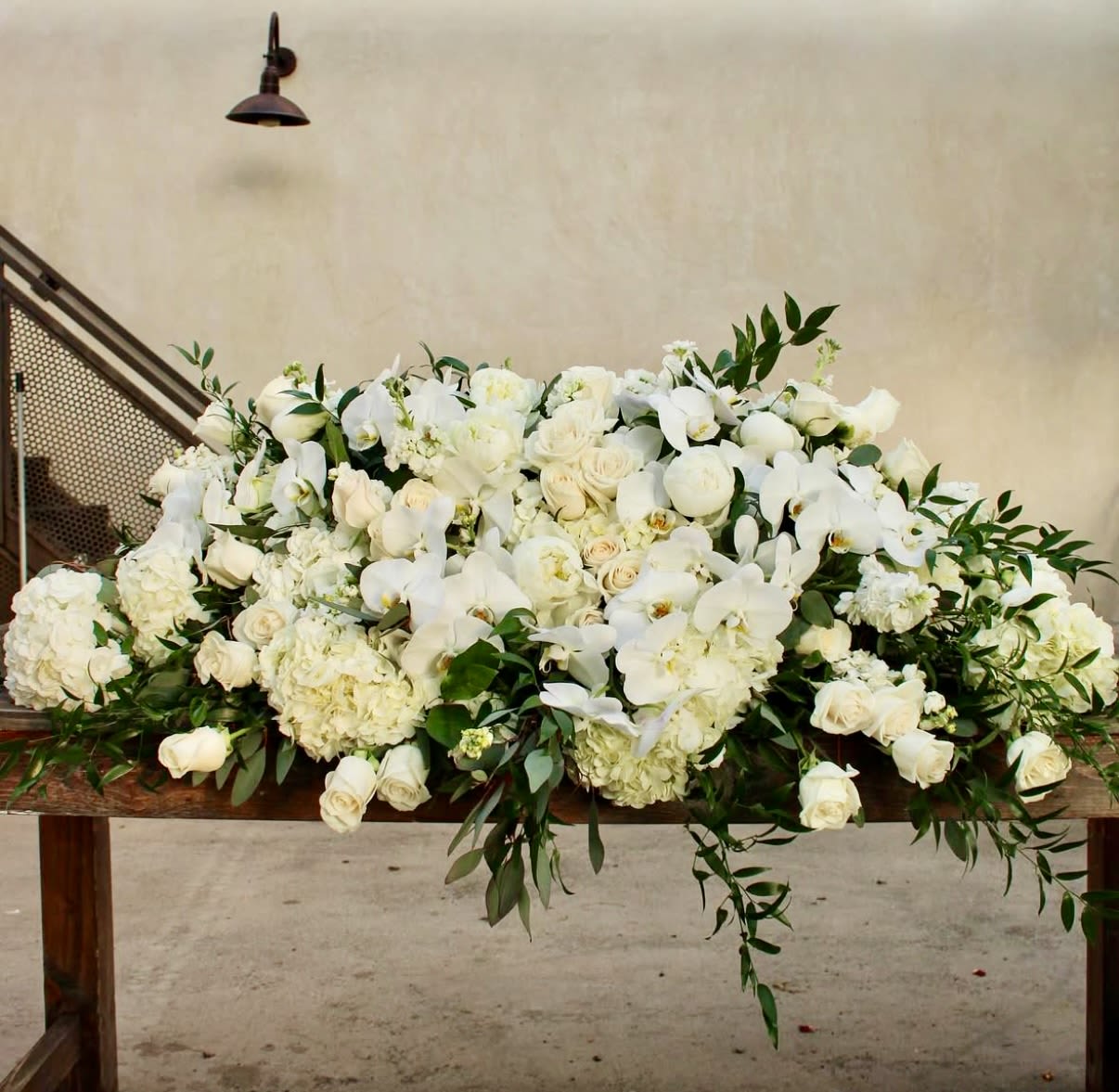 Large white floral arrangement on a wooden table