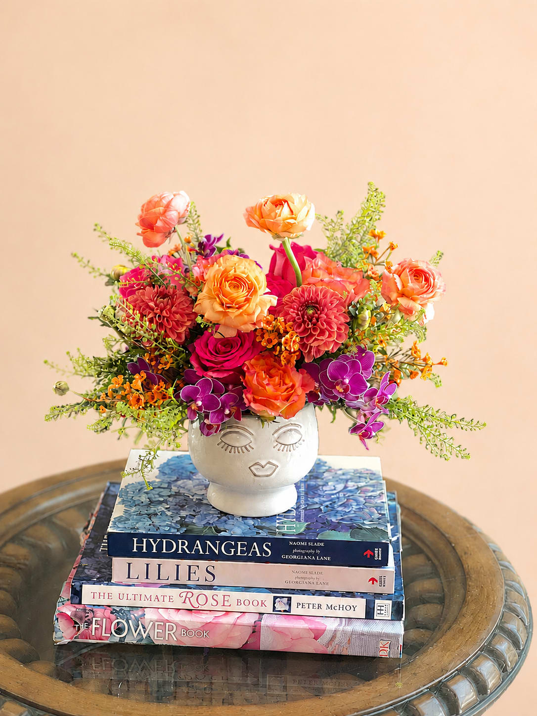 Suprise Me  - Flowers: free spirit roses, orange dahlias, orange waxflower, hot pink roses, green Limonium, mini purple orchids.   Arranged in our small Face Planter 
