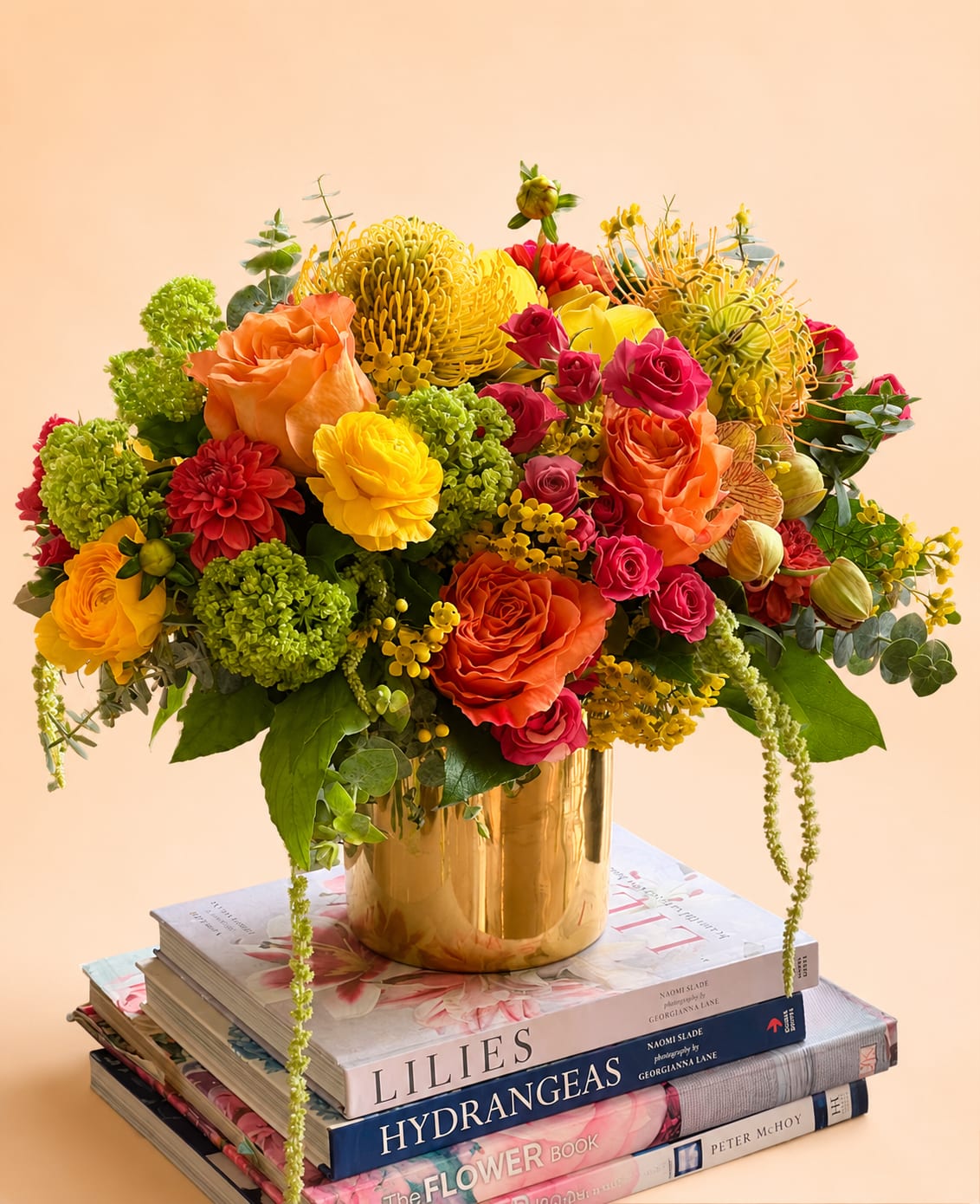 Golden Hour - Flowers: free spirit roses, yellow ranunculus, hot pink spray roses, green viburnum, green hanging amaranthus, orange orchids, yellow waxflower,  yellow cymbidium, yellow pin cushion, and eucalyptus accents.   Vase: 5x5 gold vase 