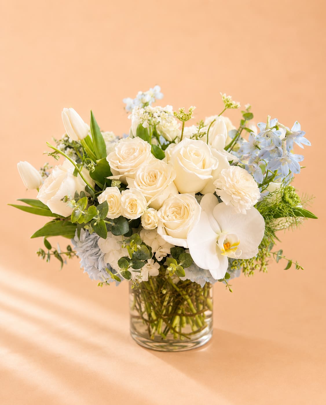 Spring Refresh  - Flowers: white playa blanca roses, white phalaenopsis orchids, white tulips, white spray roses, light blue delphinium, light blue hydrangea, orlaya and baby blue eucalyptus.  