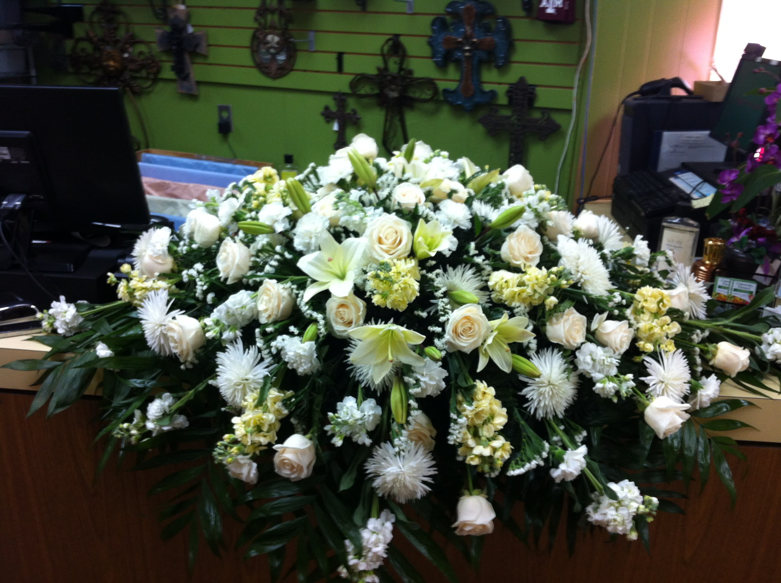 Large white floral casket spray with roses and lilies