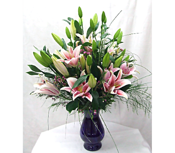 Pink lilies arranged in a dark glass vase